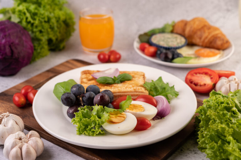 breakfast-consists-bread-boiled-eggs-black-grape-salad-dressing-tomatoes-sliced-onions (1)